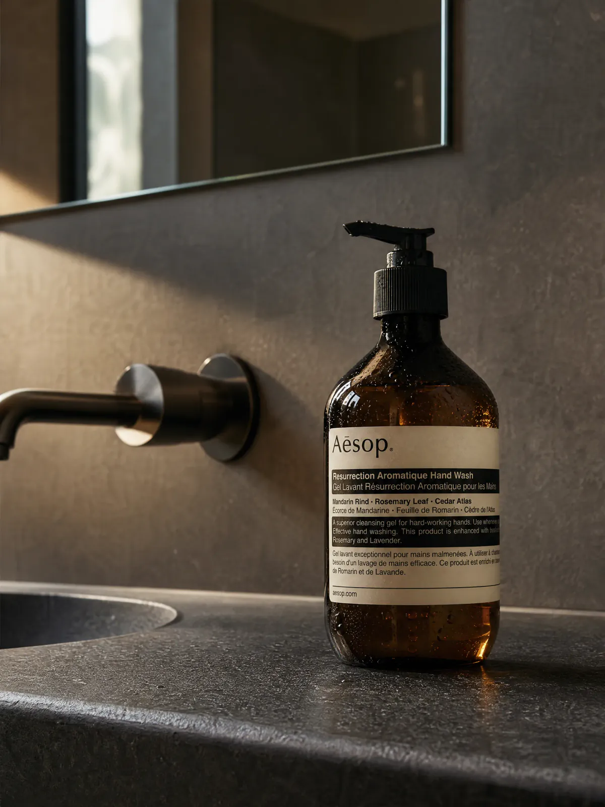 An amber pump bottle photographed in an existing hand-care scene.