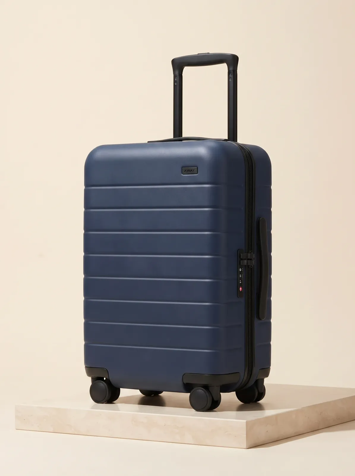 A centered product-detail image of a navy carry-on suitcase.